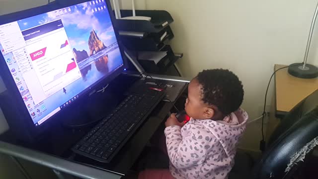 Funny baby playing with computer