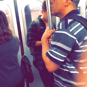 Man kissing pole in subway car