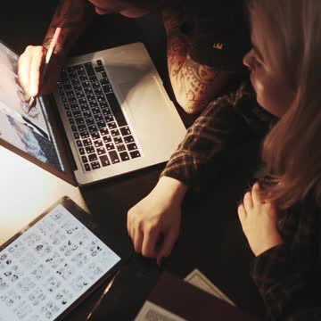 Man Tracing Tattoo Design from Laptop Screen