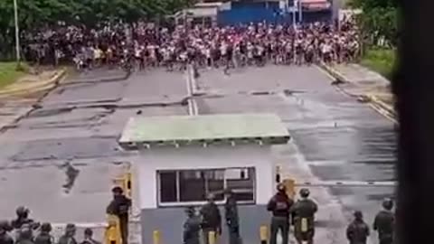 People chant “FREEDOM! FREEDOM!” in front of a military airport and base for