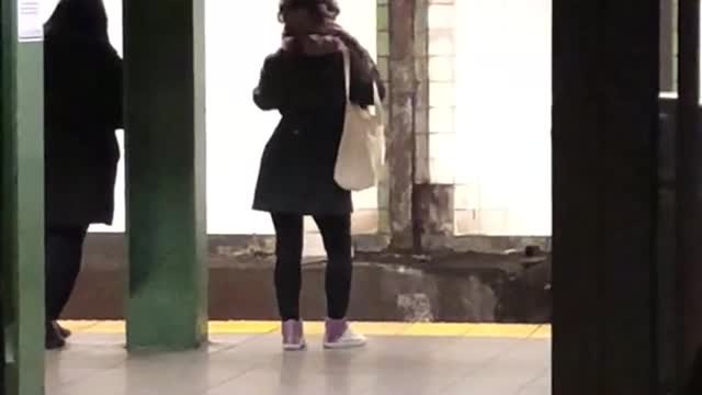 Woman dances in subway station while waiting for her train