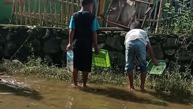 the flood slowly began to recede, the children around tried to catch fish part2