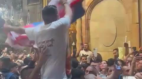 A Palestinian man carries a Russian flag during the Holy Fire ceremony inside the Church