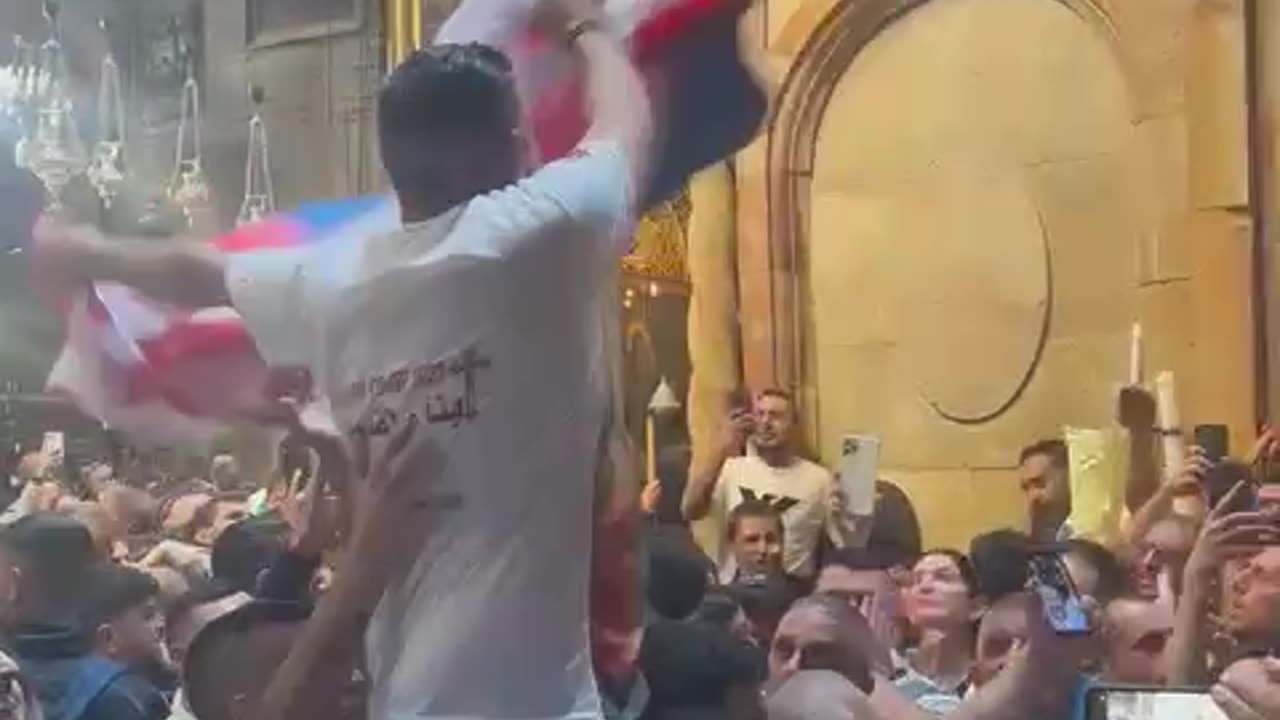 A Palestinian man carries a Russian flag during the Holy Fire ceremony inside the Church