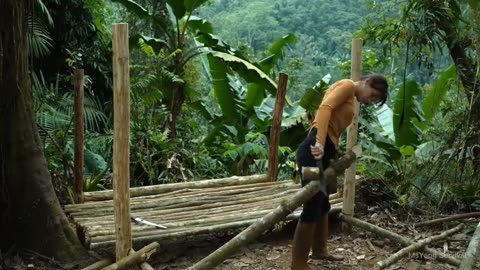 Despite the rain, building wood survival shelter in wildland. Bushcraft camp