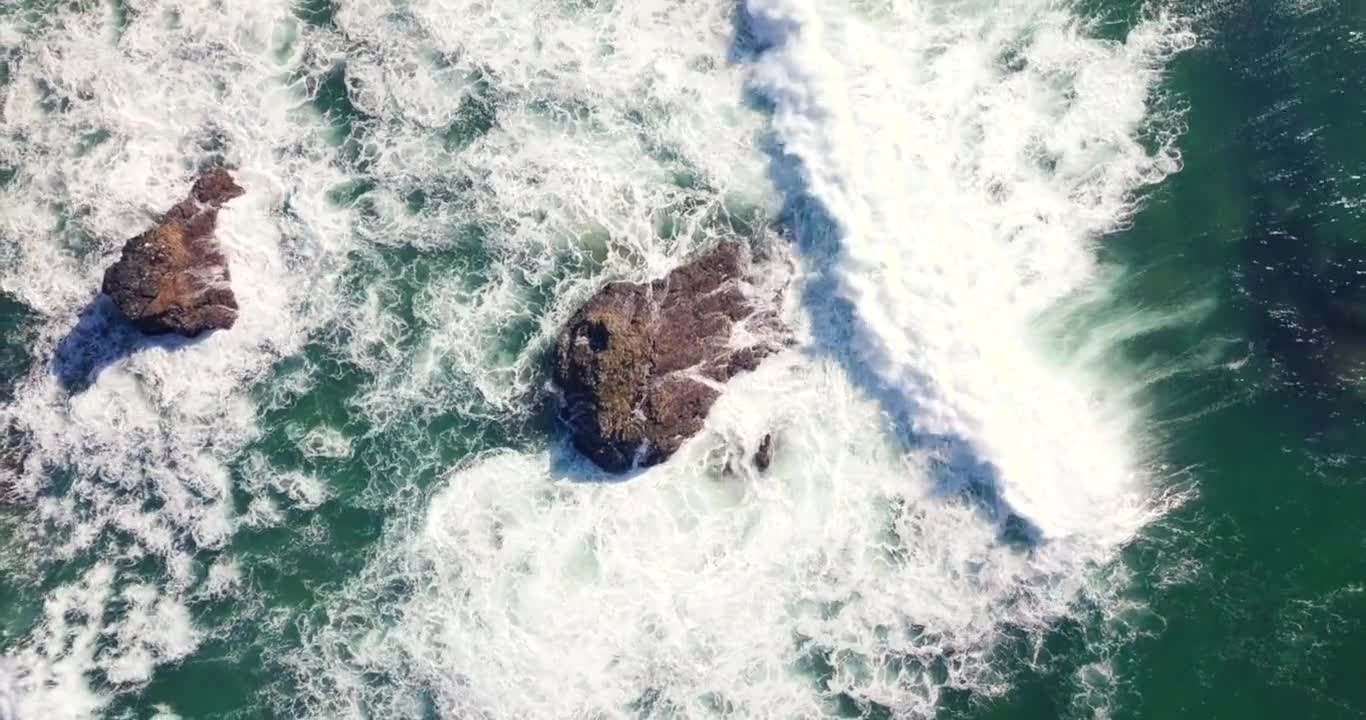 Waves crashing against boulders.