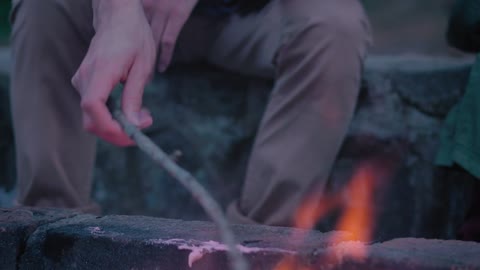 Father and daughter in nature roasting marshmallows in nature