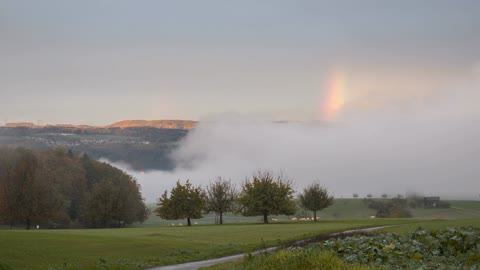 The most beautiful landscape from Switzerland covered in fog and rainbow in 4K quality