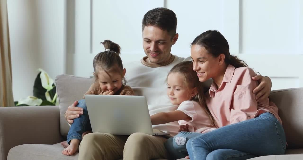 happy family couple watching funny movie cartoons with children Using Personal Computer Laptop