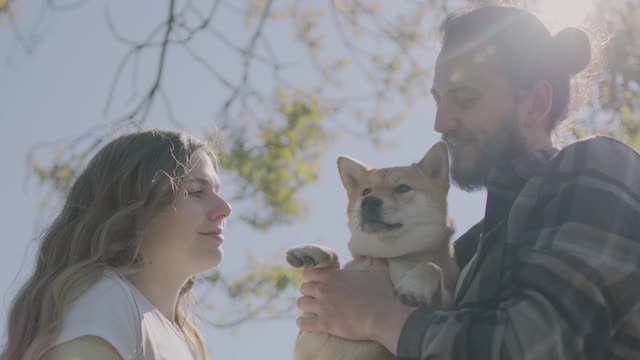 Couple Kissing Their Pet Dog