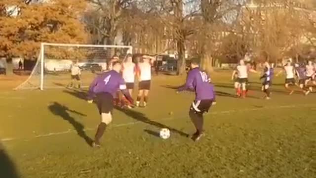 Two boys are playing football in the sunset