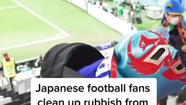 Japanese football fans clean up rubbish from the stadium after World Cup match