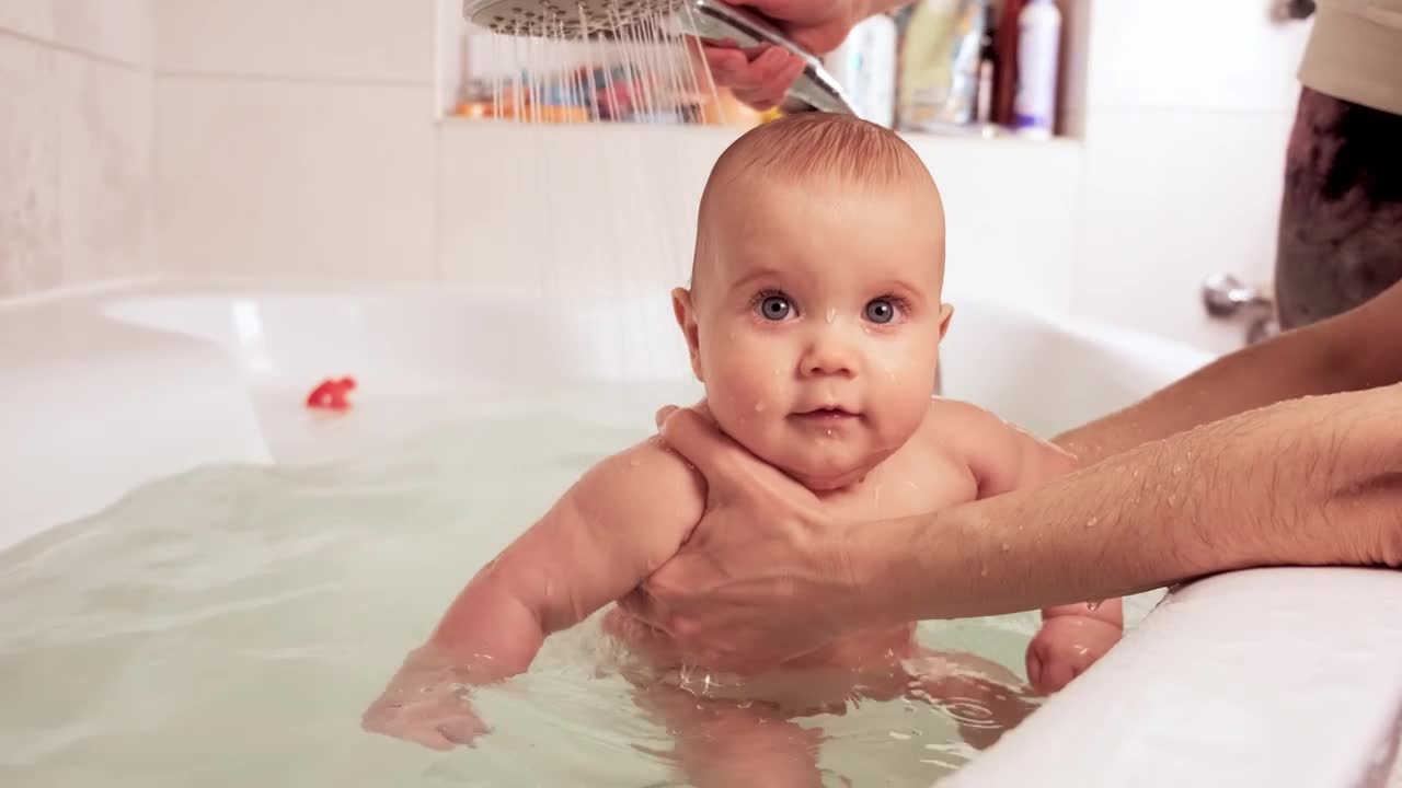 Happy baby being bathed in the tub