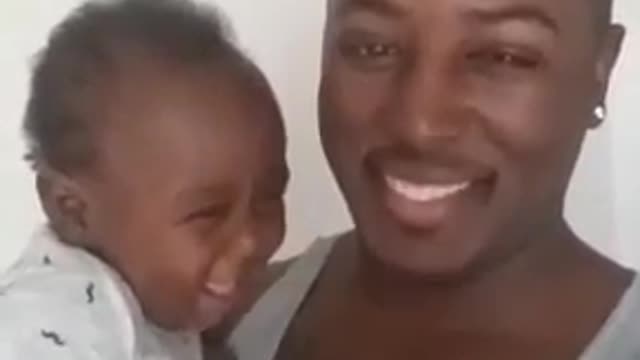Baby is cheerful and laughs with his father