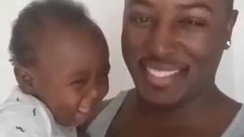Baby is cheerful and laughs with his father