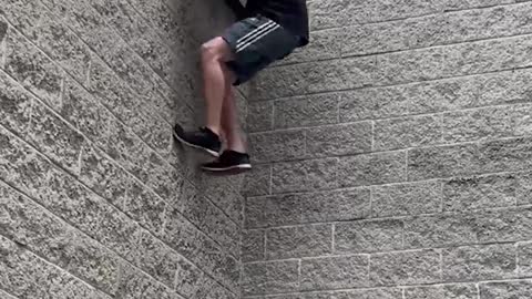 this guy is trying to run on a high wall