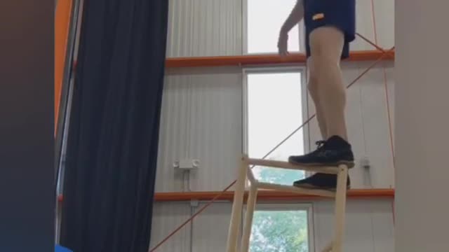 Circus Artist Balances on Inverted Acrobatic Chair