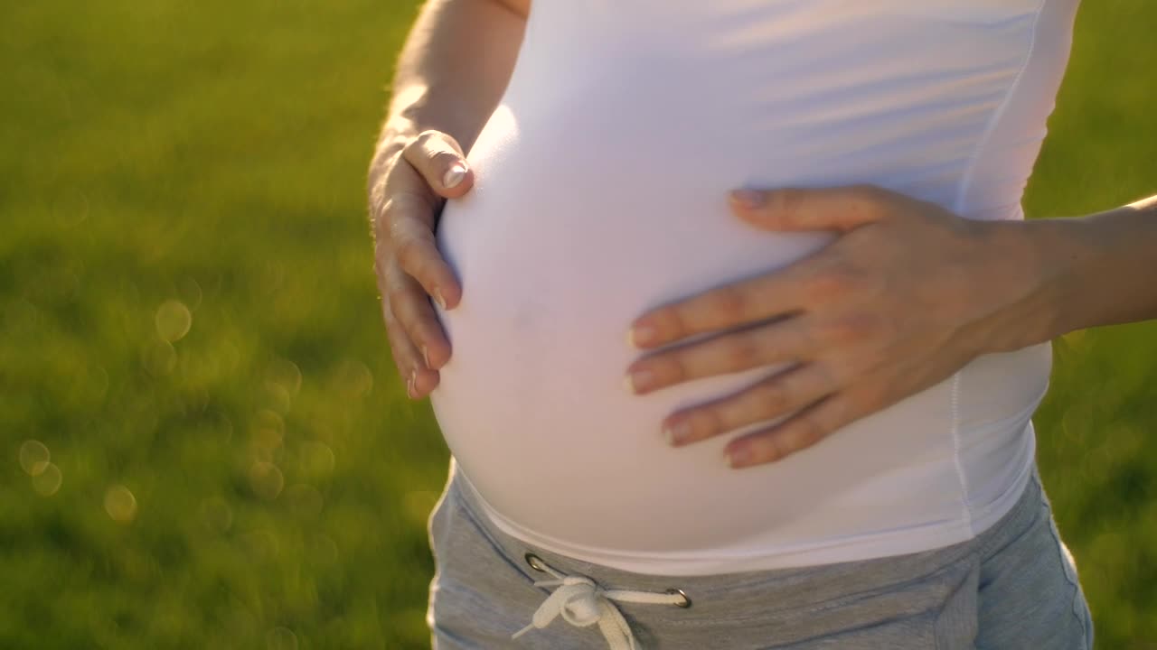 Pregnant woman stroking her baby