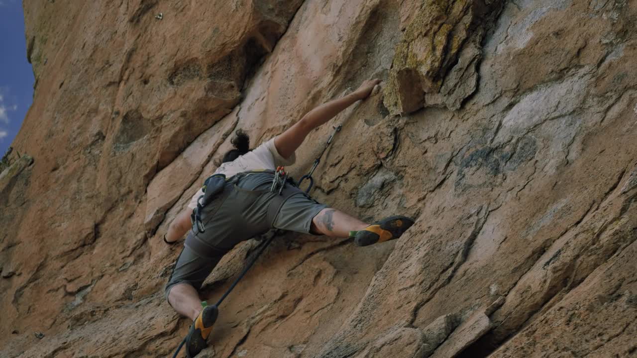 Boy climbing up a rocky mountain