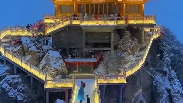 A Chinese temple during an evening snowfall in the mountains