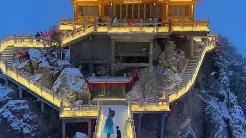 A Chinese temple during an evening snowfall in the mountains