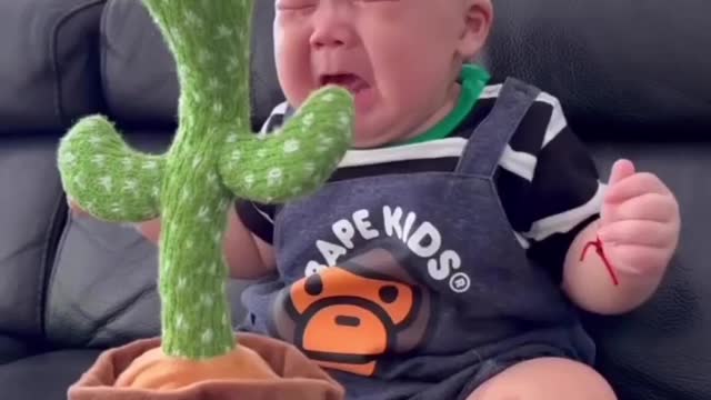 Crying baby playin with toy