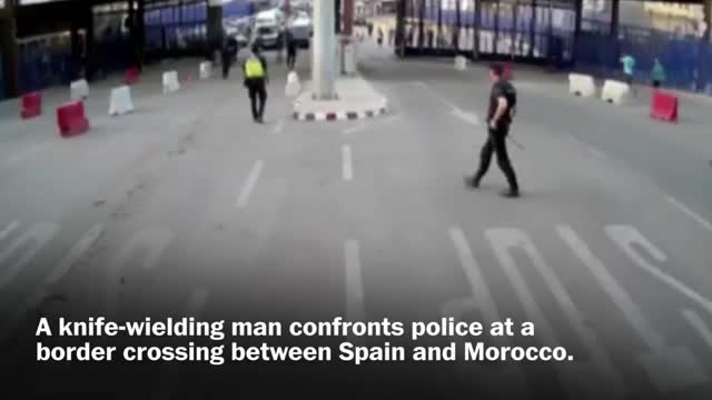 Spanish police throw traffic barrier at knife-wielding man