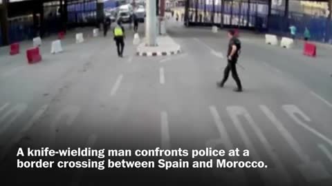 Spanish police throw traffic barrier at knife-wielding man