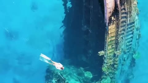 In the clear waters surrounding Keioda, Maldives, lies a sunken ship half submerged.