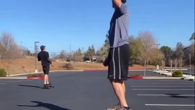Guy Standing on Balance Board Plays Catch With Skateboarder