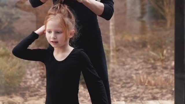 A mother who repairs her child's hair while dancing and exercises,