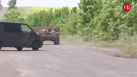 Ukraine military vehicles drive on dusty roads near retaken villages