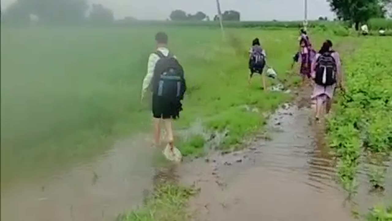 School going child through the rain water