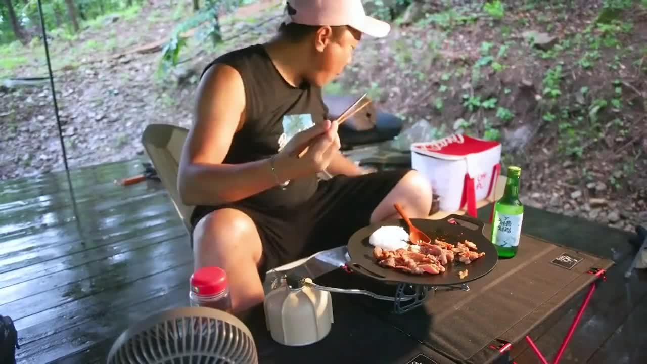 Camping in the rain, enjoying outdoor food alone