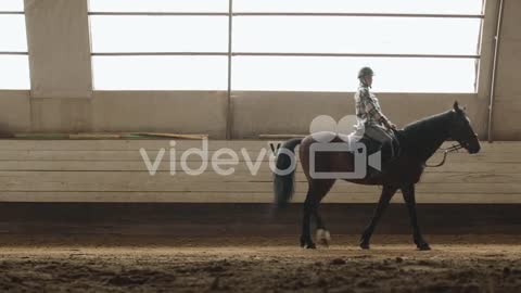 Side View Of Woman Riding A Horse