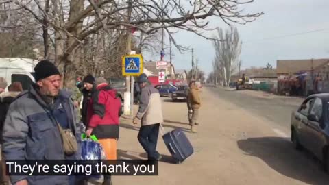 Civilians travel by armored vehicle to safety