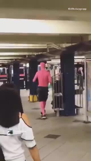 Man in all pink body suit and black shorts