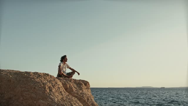 Man Sitting On Cliffside