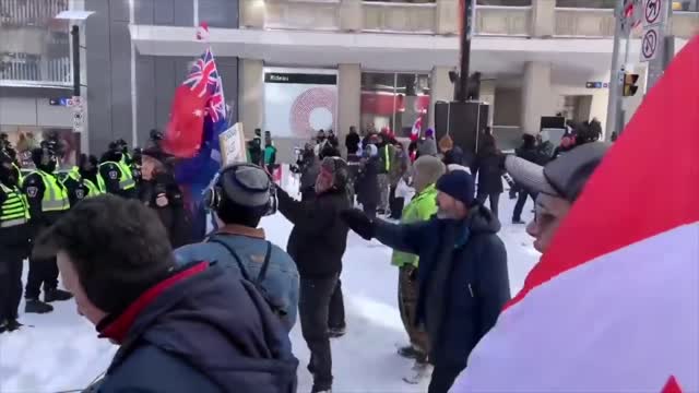 CANADIANS SING NATIONAL ANTHEM TO POLICE LINE