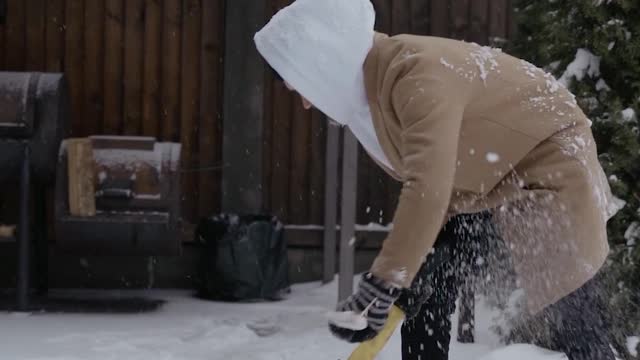 Man Chopping Firewood Under Blizzard