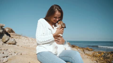 Young adult woman playing with little dog