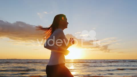 Young Woman Running On The Beach