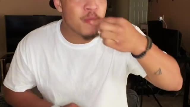 Man eats hot cheetos with hot sauce