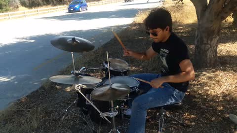 Drummer on road median in 100 degree weather