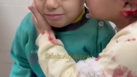 Una bambina palestinese conforta il suo fratellino dopo che ....