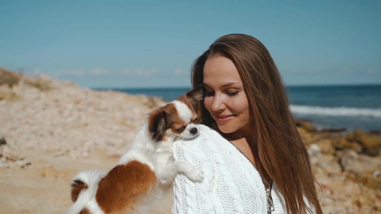 Young adult girl spending day on beach with little dog