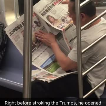 Man holds and touches a picture on a newspaper
