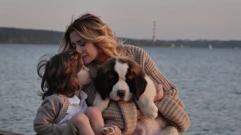 Little boy with mother near the sea playing with their dogs