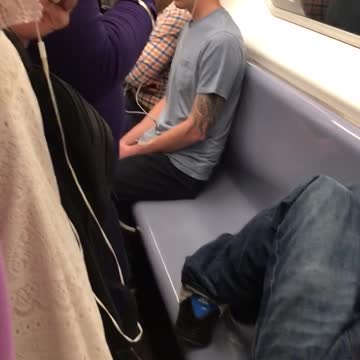 Guy sleeping on blue seats subway train rush hour