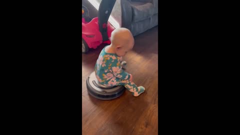 cute little baby goes for ride on robot vacuum